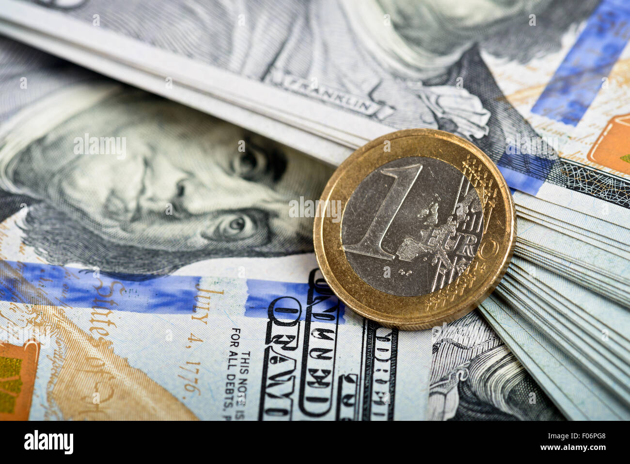 Dettaglio di una moneta in euro, su dollar note in background Foto Stock