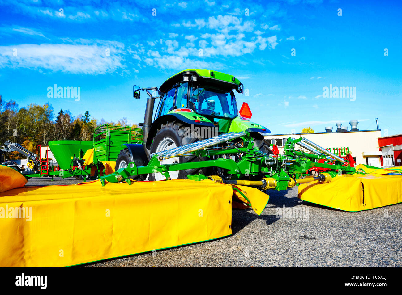 Trattrice agricola con grandi rasaerba e aratro Foto Stock