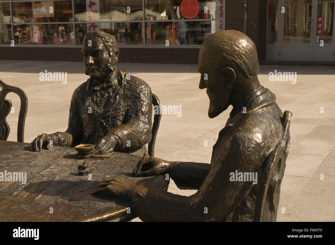 L'Europa, la Polonia, a Lodz, Łódź, Ulica Piotrkowska, statua ornamentale di uomini a tavola la scrittura e di bere il caffè Foto Stock