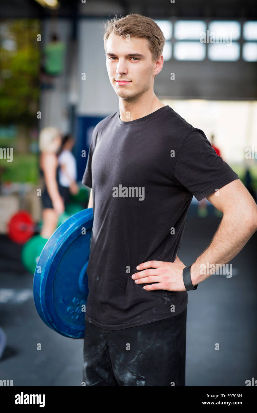 L'uomo porta pesi in palestra per il fitness center Foto Stock