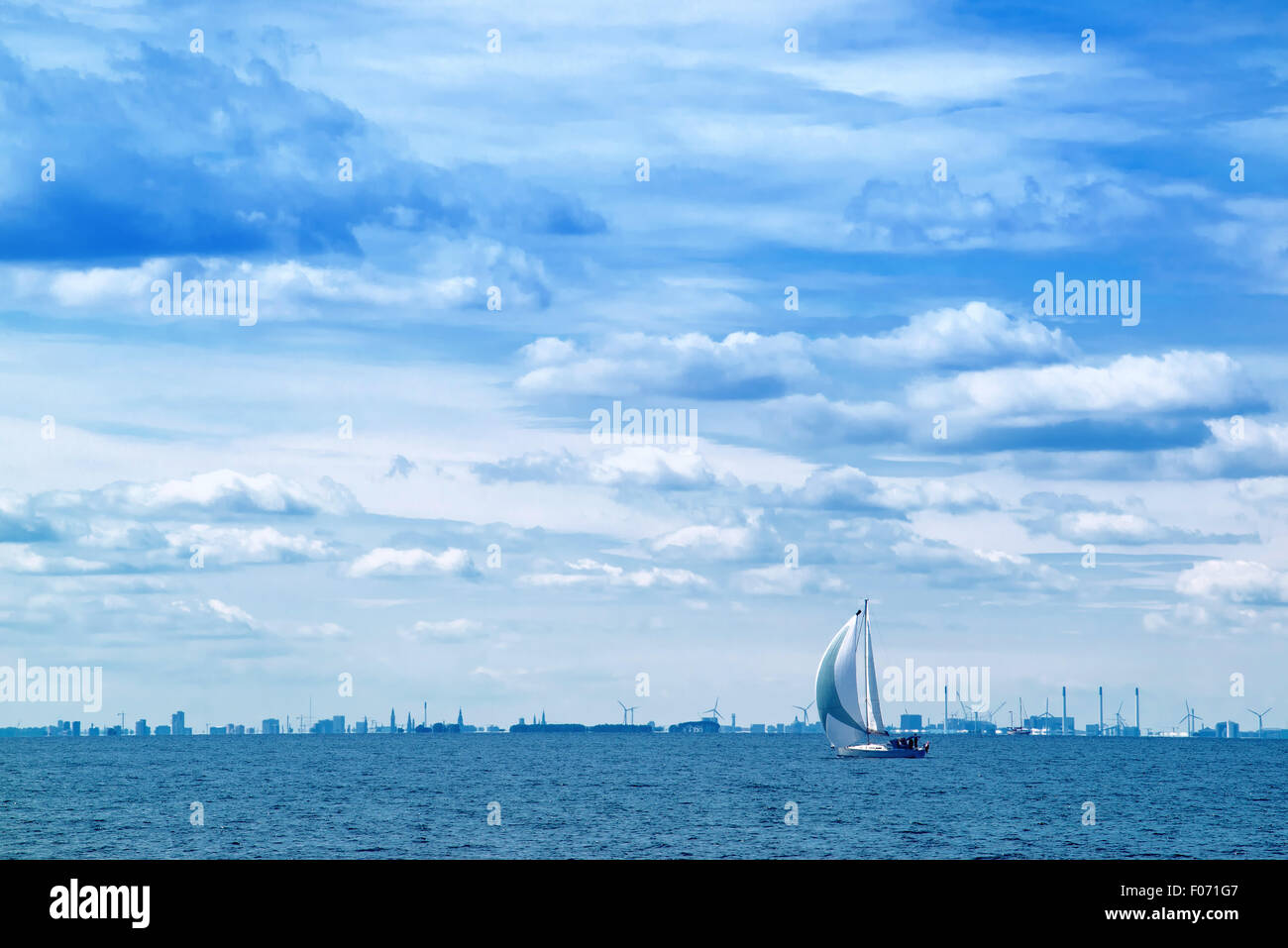 Barca a vela aperta sul mare blu, nuvole temporalesche a Sky, incerto futuro del concetto Foto Stock