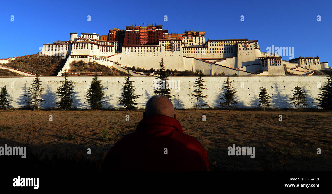 (150809) -- LHASA, e il Agosto 9, 2015 (Xinhua) -- Un monaco prega presso il palazzo del Potala square a Lhasa, capitale del sud-ovest della Cina di regione autonoma del Tibet, Dic 10, 2013. Promossa dal governo, il Potala square, come altre infrastrutture pubbliche in Tibet, è stato in gran parte migliorato negli ultimi dieci anni. (Xinhua/Chogo) (mt) Foto Stock