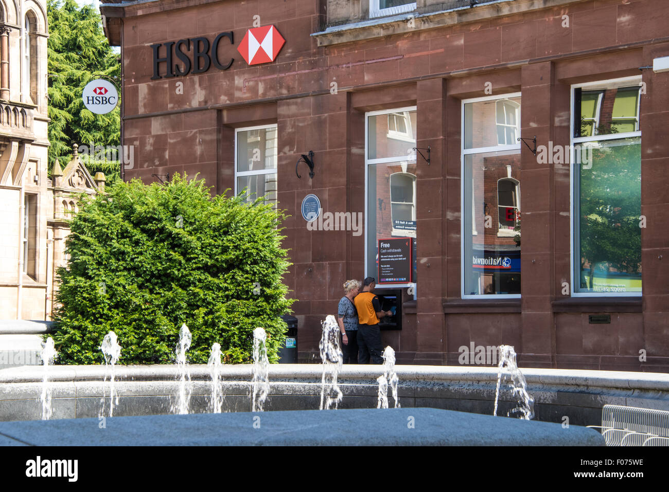Un paio utilizzando il punto di contanti macchina della HSBC Bank su high street Wolverhampton West Midlands, Regno Unito Foto Stock