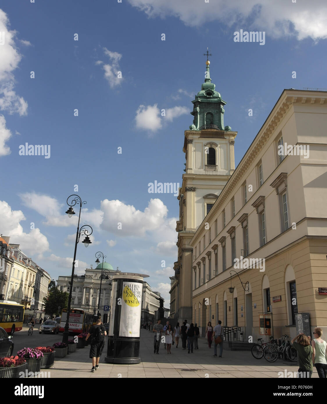 Cielo blu, il bianco delle nuvole ritratto la gente camminare marciapiede Krakowskie Przedmiescie alla chiesa di Santa Croce e Palazzo Staszic, Varsavia Foto Stock