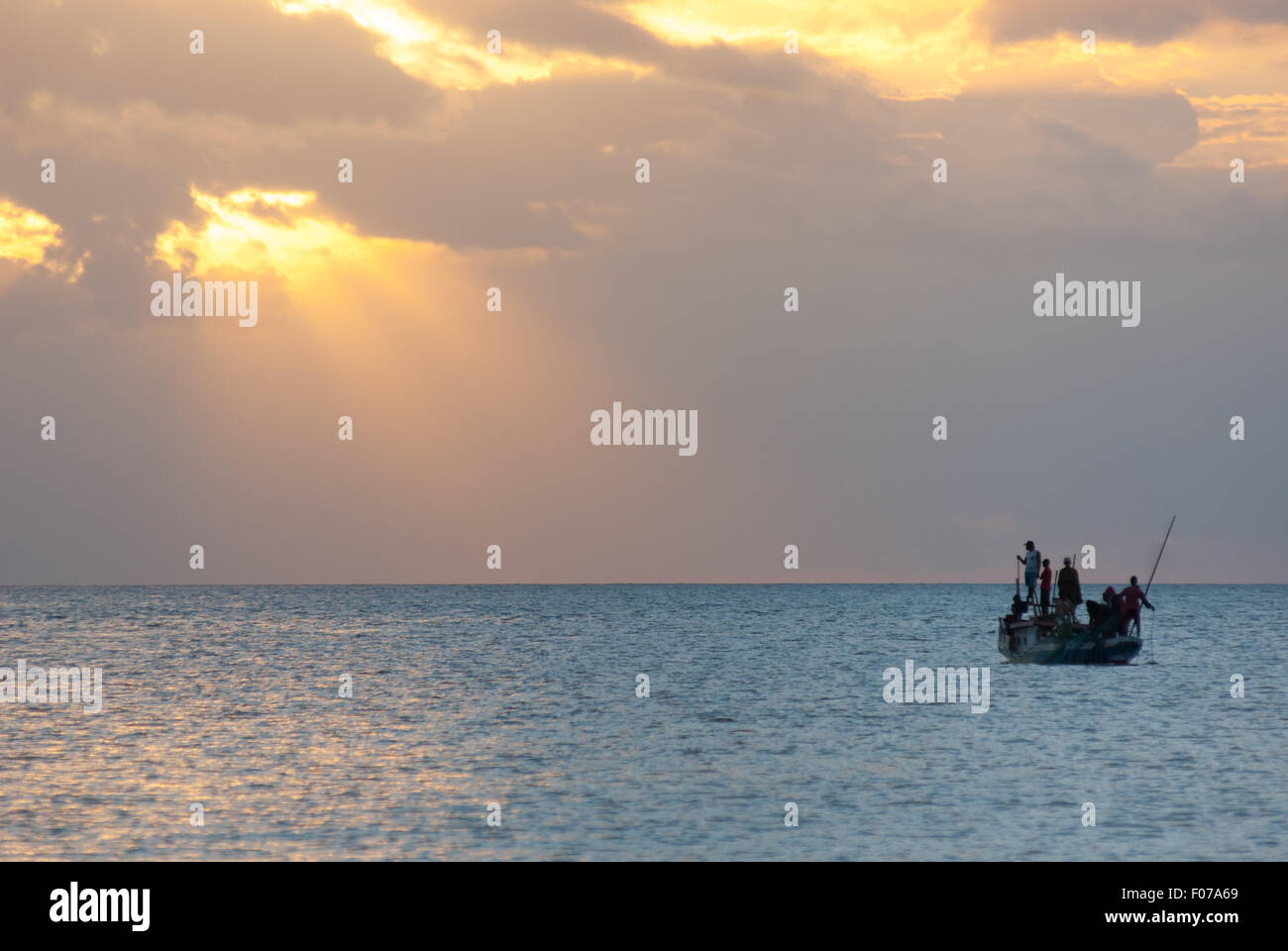 La barca da pesca che scivola sul mare di Savu intorno al tramonto al largo della costa dell'isola di Rote, vista da Batu Termanu a Rote Ndao, Nusa Tenggara orientale, Indonesia. Foto Stock