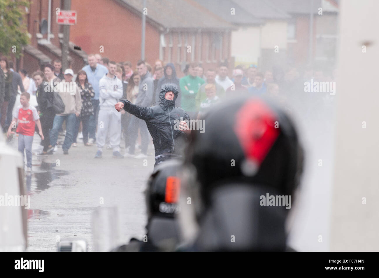 Belfast, Irlanda del Nord. 09 ago 2015 - Una gioventù nazionalista getta una pietra a PSNI ufficiali mentre viene spruzzata da un cannone ad acqua in seguito ad un anti-internamento rally. Credito: Stephen Barnes/Alamy Live News Foto Stock