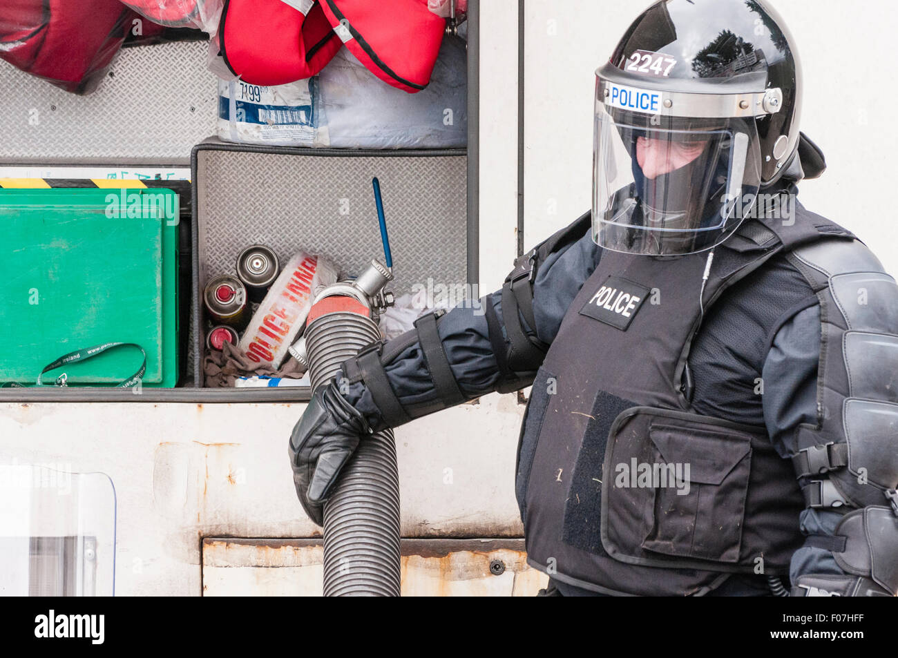 Belfast, Irlanda del Nord. 09 ago 2015 - UN PSNI officer attribuisce un approvvigionamento di acqua per il retro di un cannone ad acqua durante una sommossa Credit: stephen Barnes/Alamy Live News Foto Stock