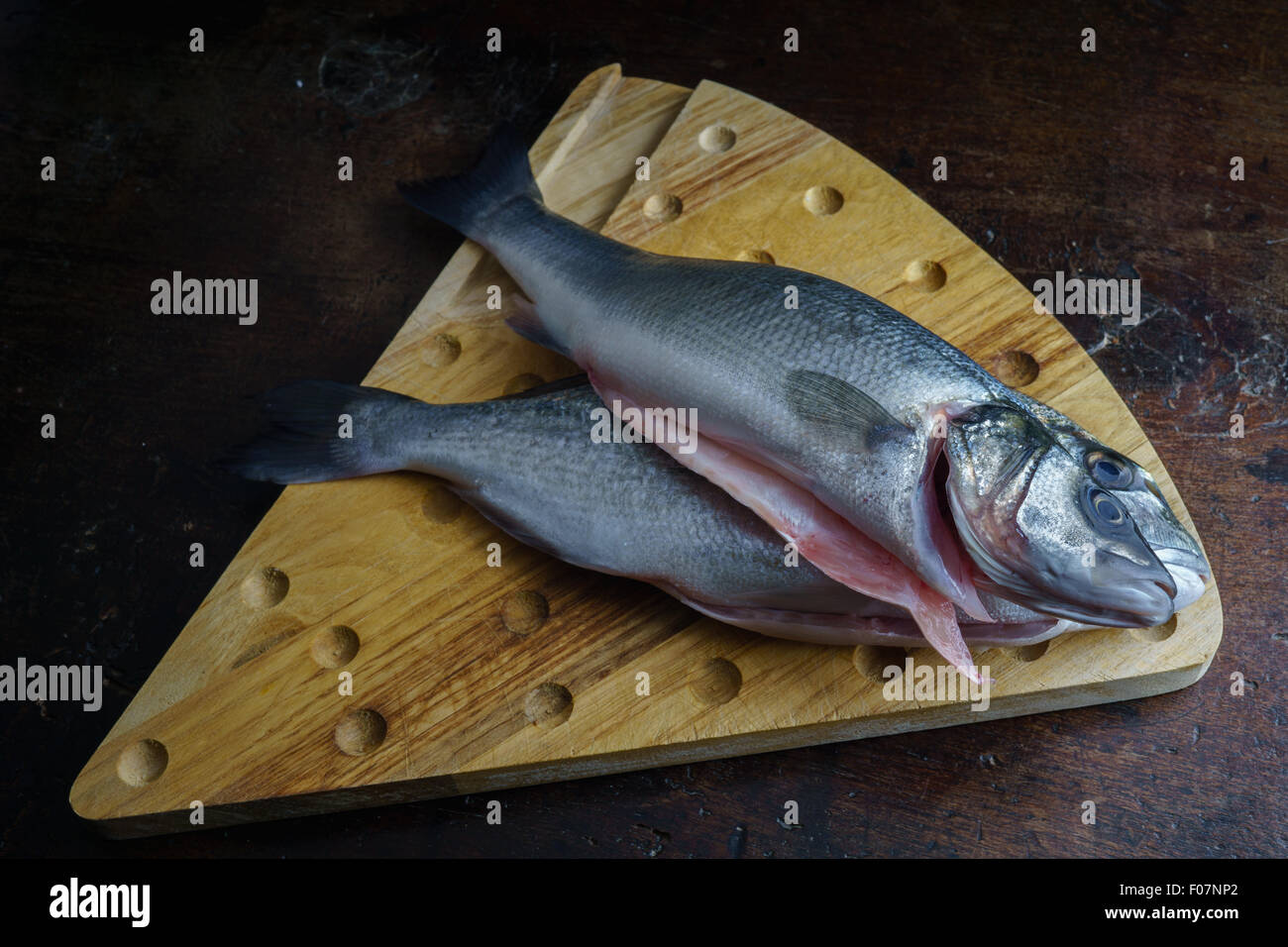 Uncoucked pesce su un vecchio tavolo marrone Foto Stock