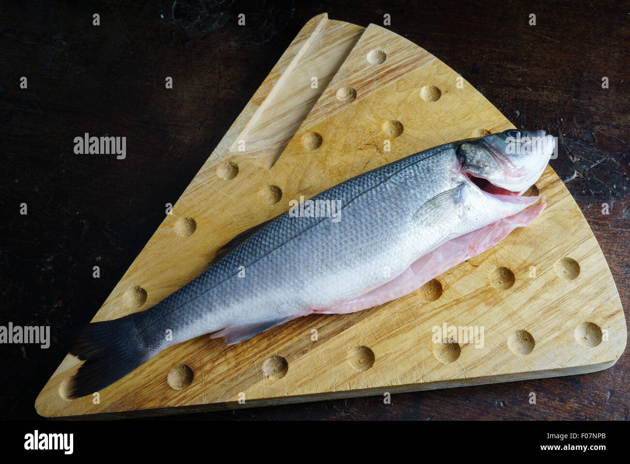 Uncoucked pesce su un vecchio tavolo marrone Foto Stock