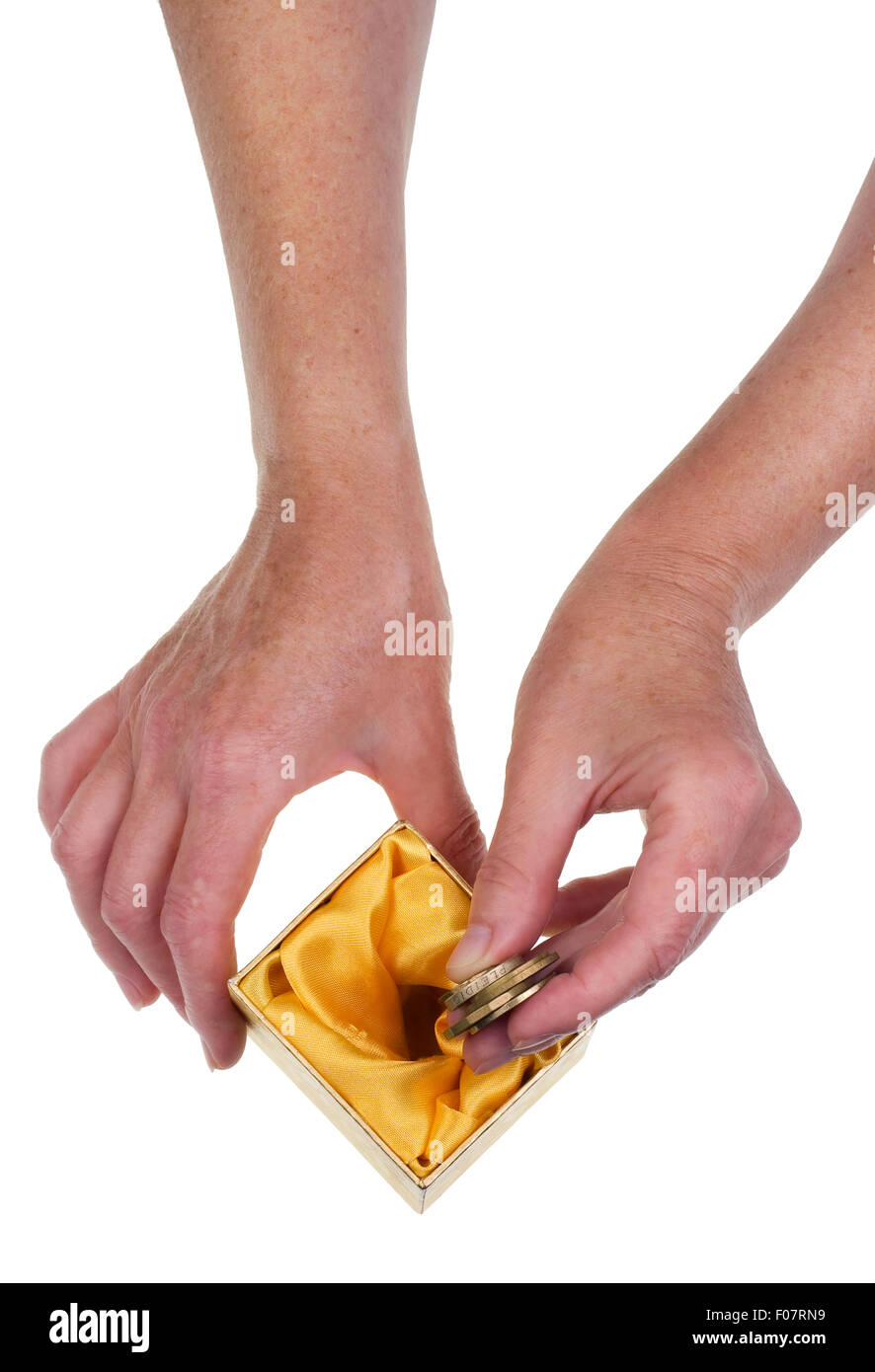 La persona anziana e risparmia fino agli ultimi soldi per il concetto di pensione. Isolate le mani e la cassetta della carta studio shot Foto Stock