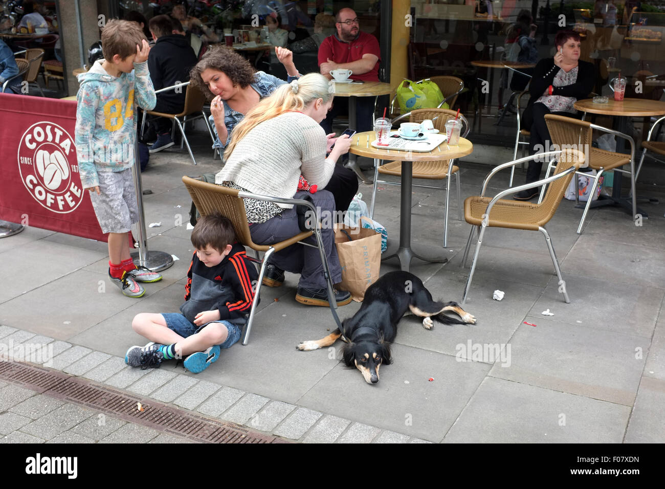 Famiglia godendo una pausa al Caffè costa nella zona salotto all'aperto a Bolton, Lancashire / Greater Manchester Inghilterra England Regno Unito Foto Stock