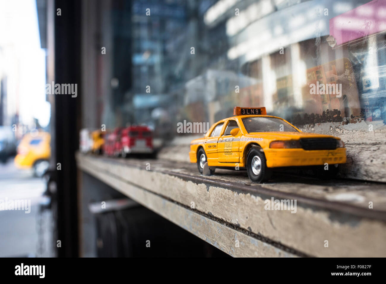 Un giocattolo New York taxi cabina si appoggia sul davanzale della finestra di un negozio di Lexington. Foto Stock