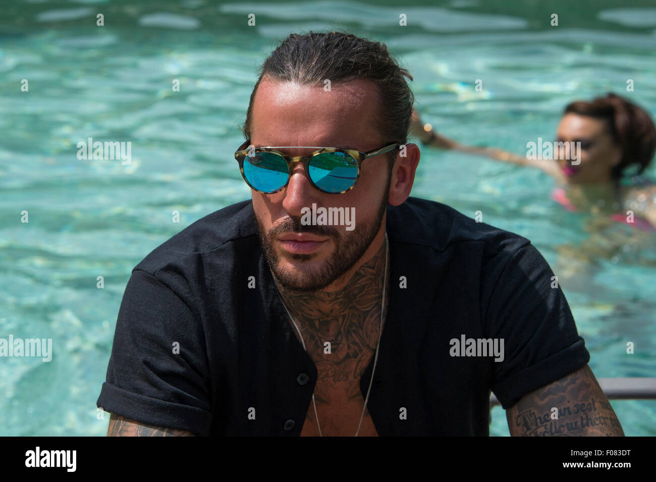 TOWIE membro del cast e nuovo cuore throb, Pietro stoppini seduti in piscina in occhiali da sole riflettente. Foto Stock