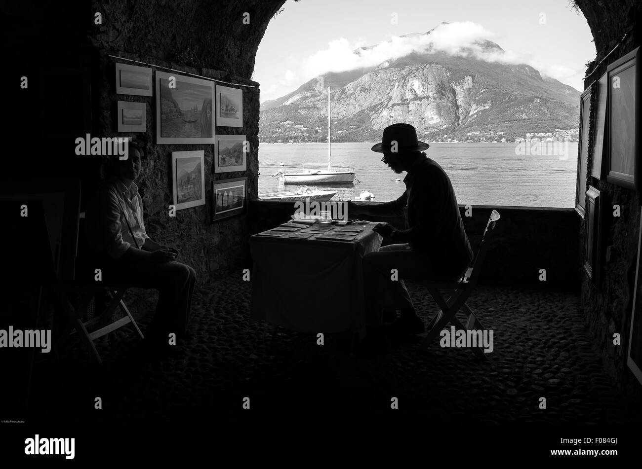 Estate 2015, Vendicari, Italia. Ritratto di un vecchio artista di strada durante il disegno di una famiglia ritrattistica Foto Stock