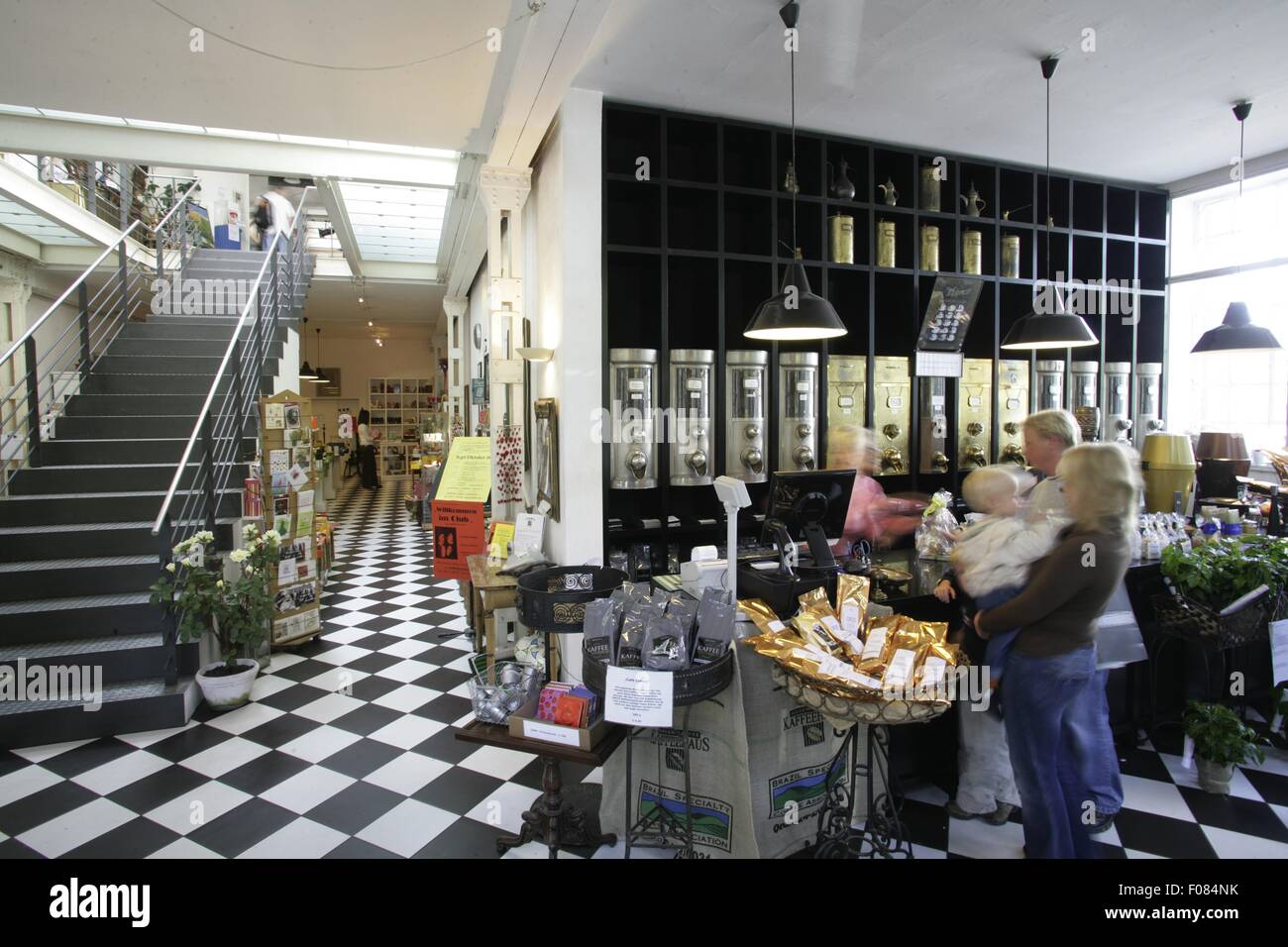 Persone in café con scalinata e nero-pavimento piastrellato di bianco, Germania Foto Stock