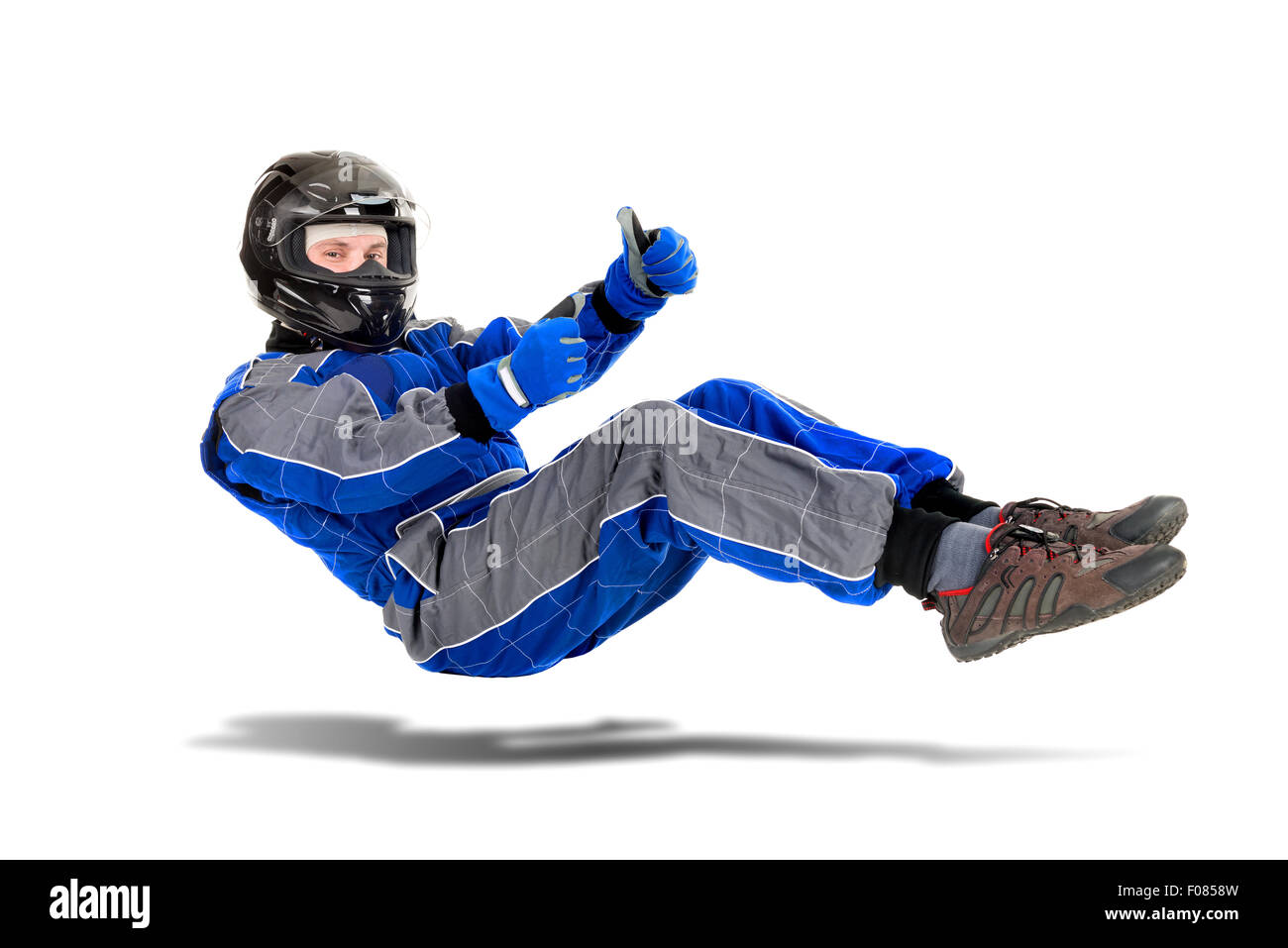 Racing driver che pongono in posizione di guida in piena marcia isolato in bianco Foto Stock