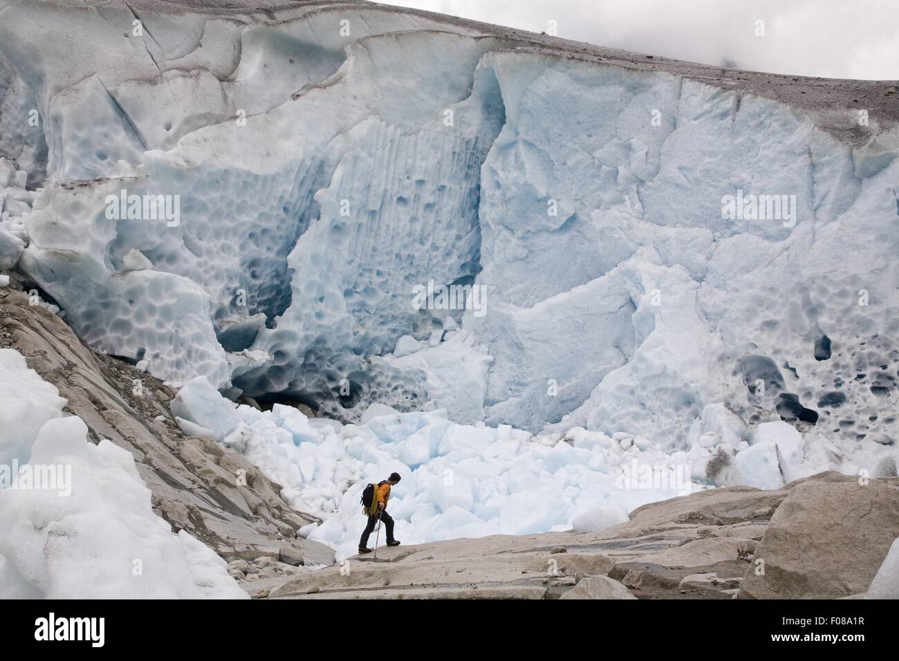 Escursionista nella parte anteriore della parete di ghiaccio nel ghiacciaio di Aletsch, Marjelesee, Vallese, Svizzera Foto Stock