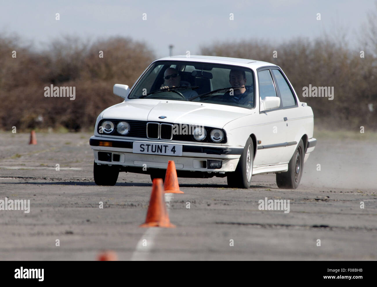 La guida per lo slalom tra i coni in una BMW auto Foto Stock