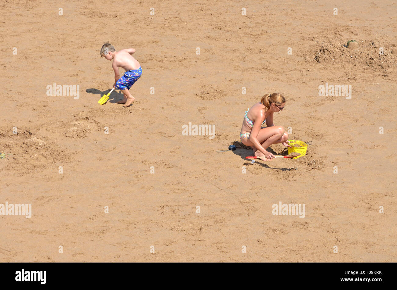 Broadstairs Kent, Inghilterra, Regno Unito. Viking Bay Beach. Madre e figlio di scavare nella sabbia Foto Stock