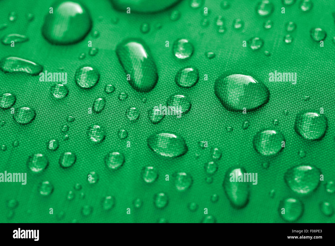 Primo piano di gocce di pioggia su una verde acqua materiale resistente Foto Stock