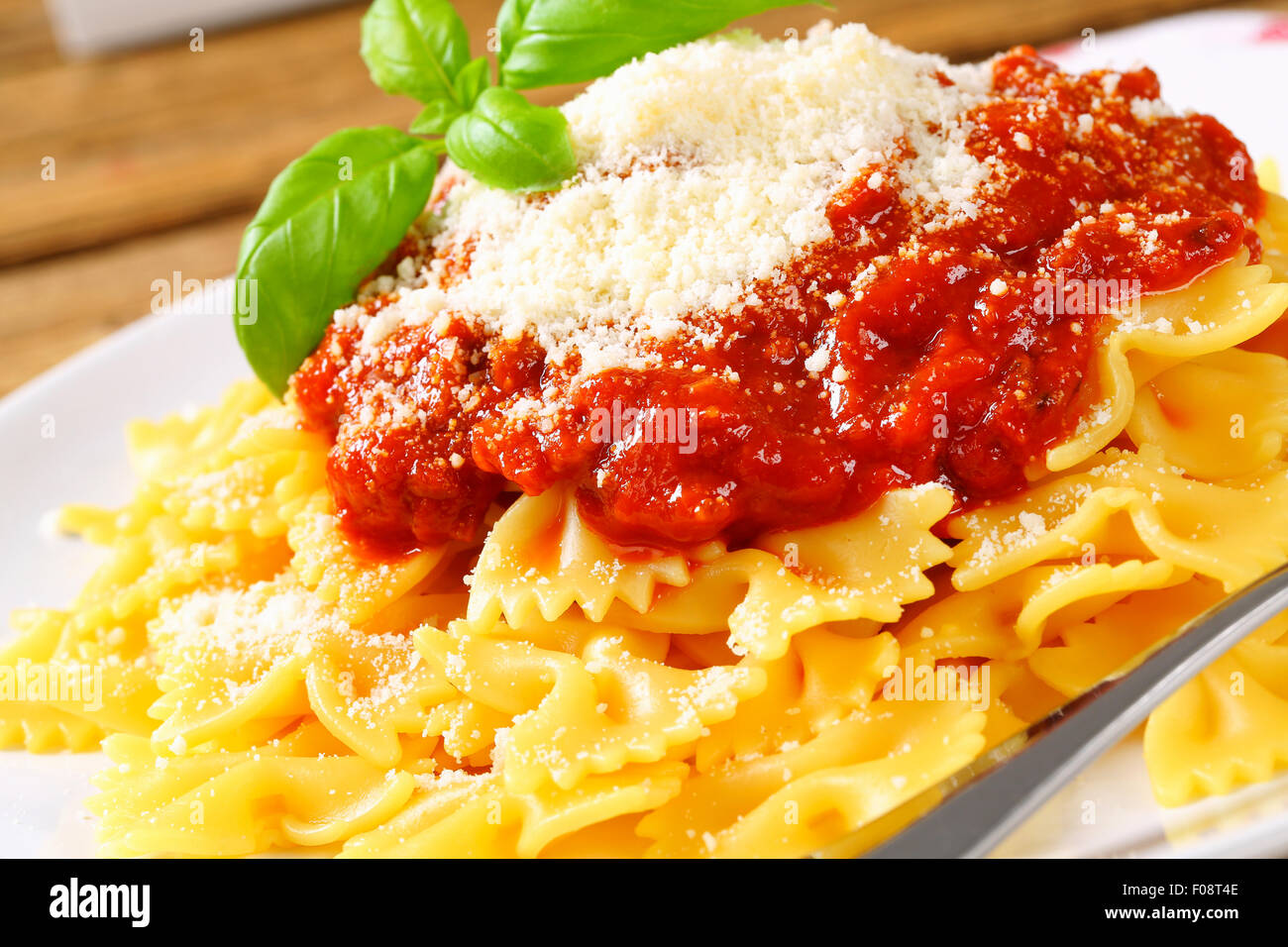 Filtro Bow tie pasta spessa con salsa di pomodoro e scaglie di parmigiano Foto Stock