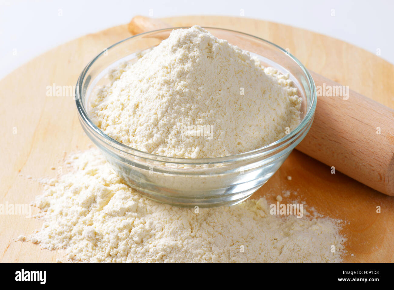 Ciotola di farina e perno di rotolamento su una tavola di legno Foto Stock