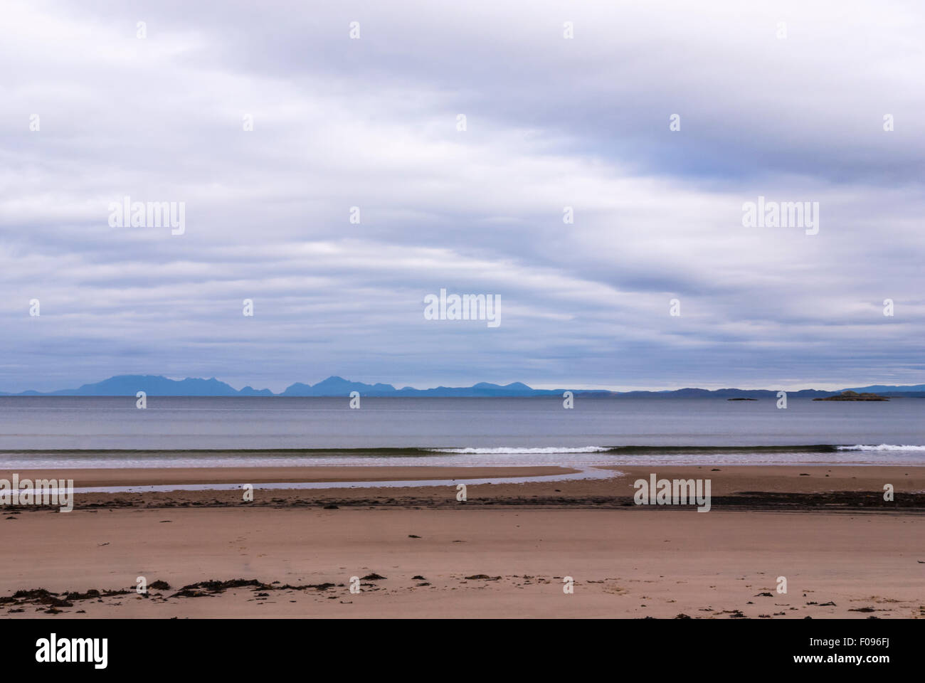 Guardando delle Ebridi isole di Eigg e rum, nella distanza, dal canto Sands, a Ardnamurchan, Scozia Foto Stock