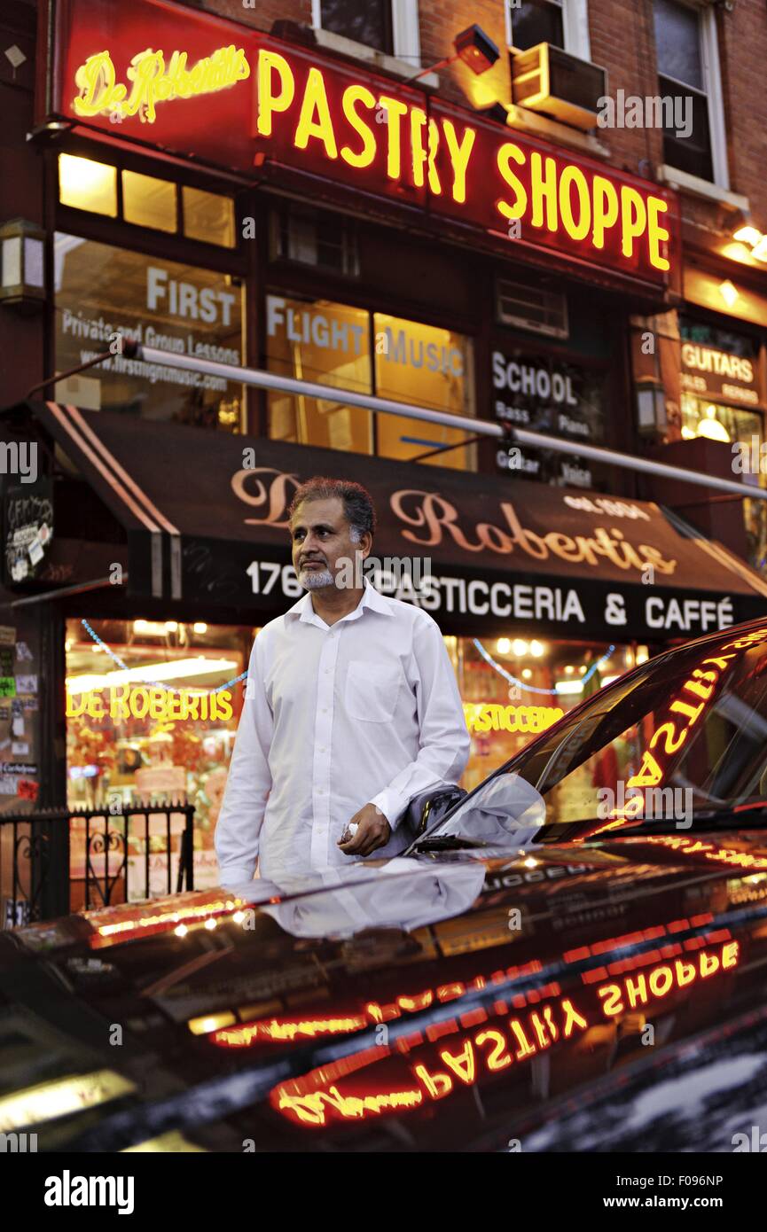 Uomo in piedi sulla strada davanti alla vettura in East Village, Manhattan, New York, Stati Uniti d'America Foto Stock