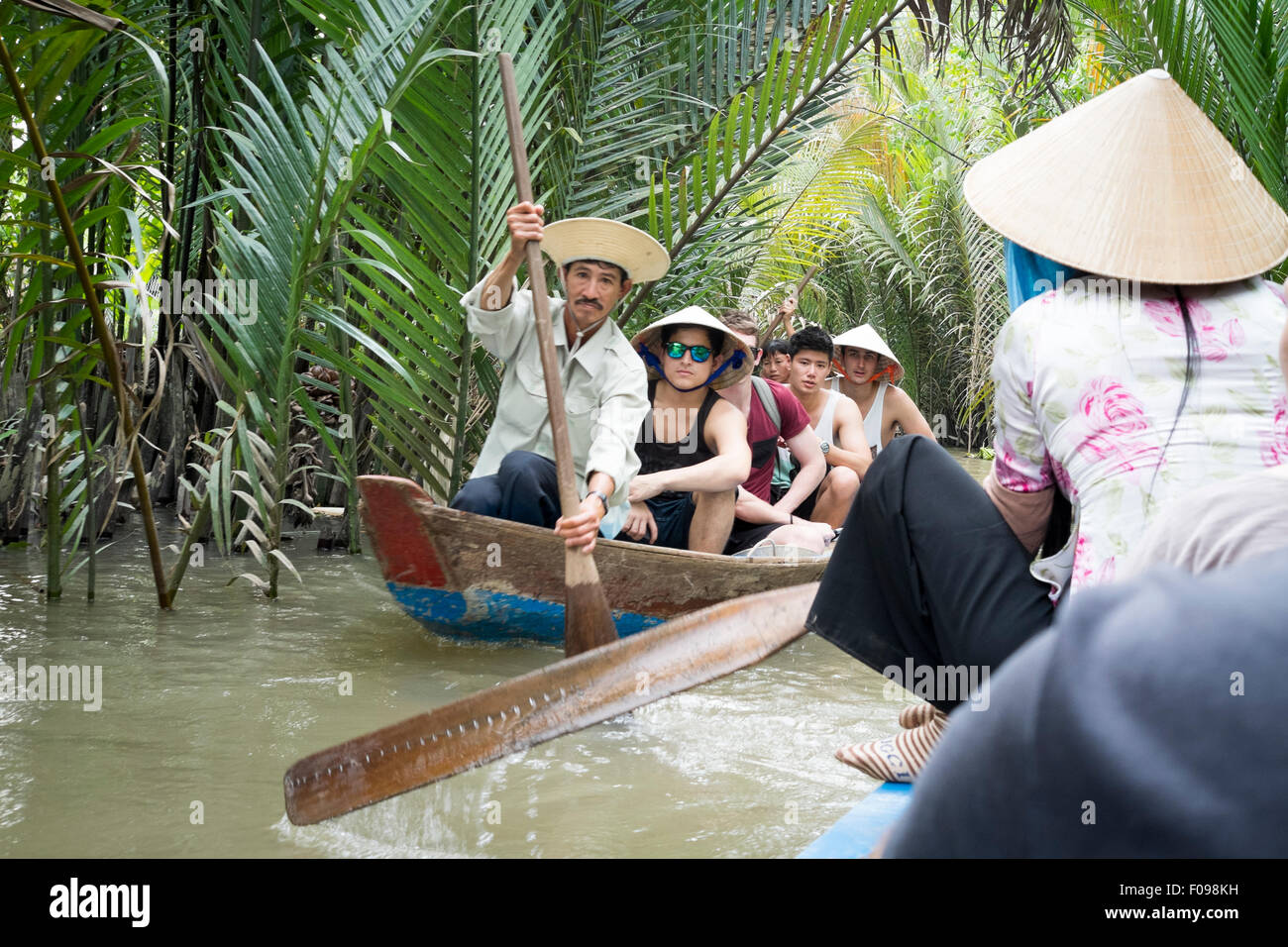 I turisti prendono una tradizionale barca sul Delta del Mekong, Vietnam del Sud Foto Stock