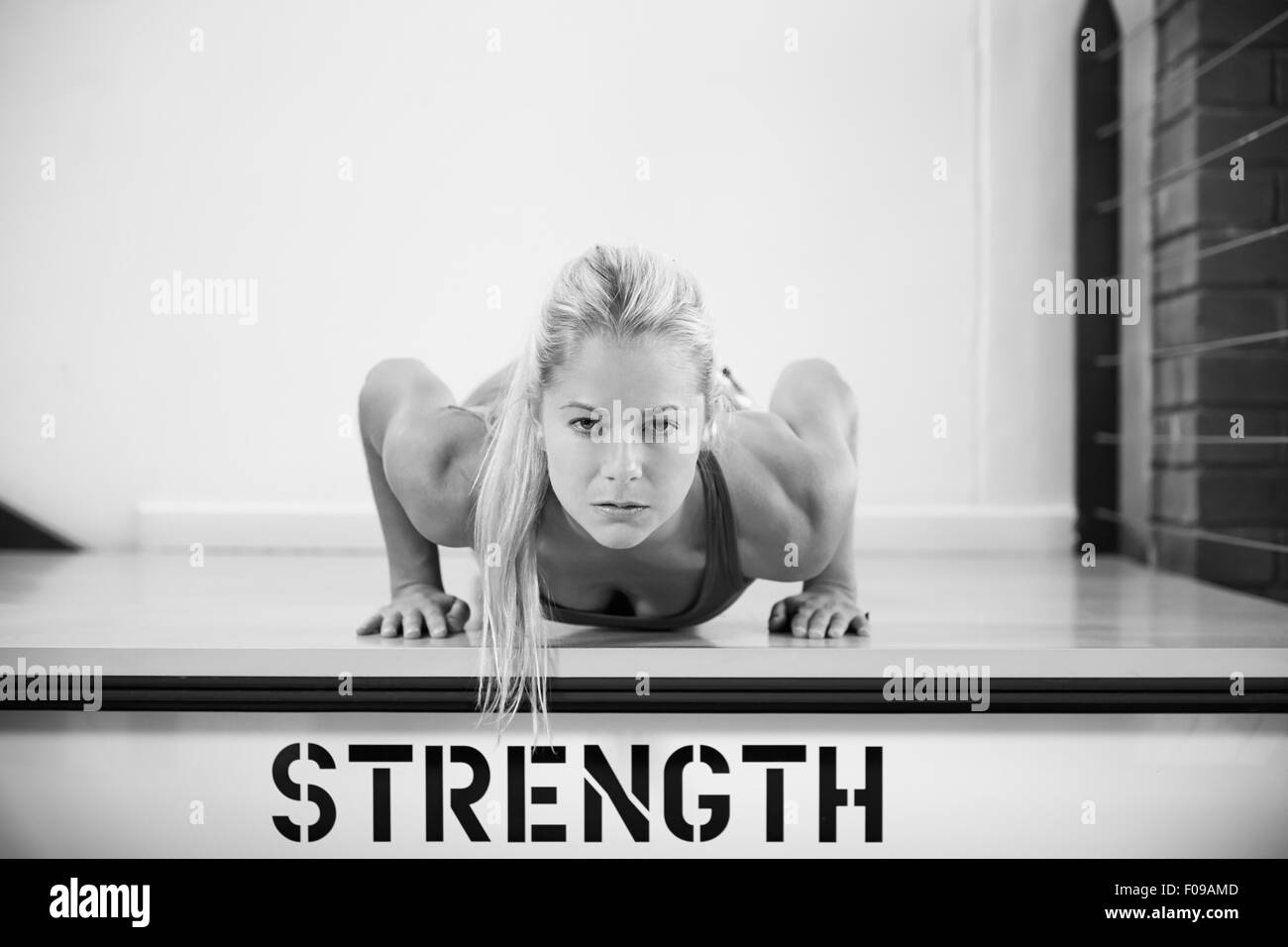 In bianco e nero girato da donna in palestra facendo Press-Ups Foto Stock