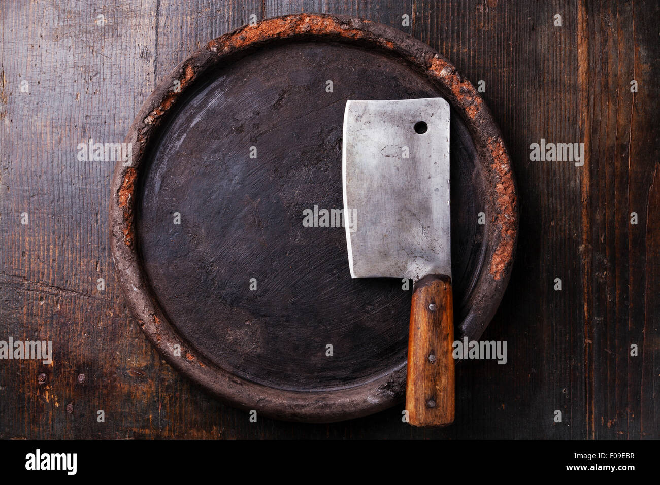 Round superficie di pietra e carne cleaver scuro su sfondo di legno Foto Stock