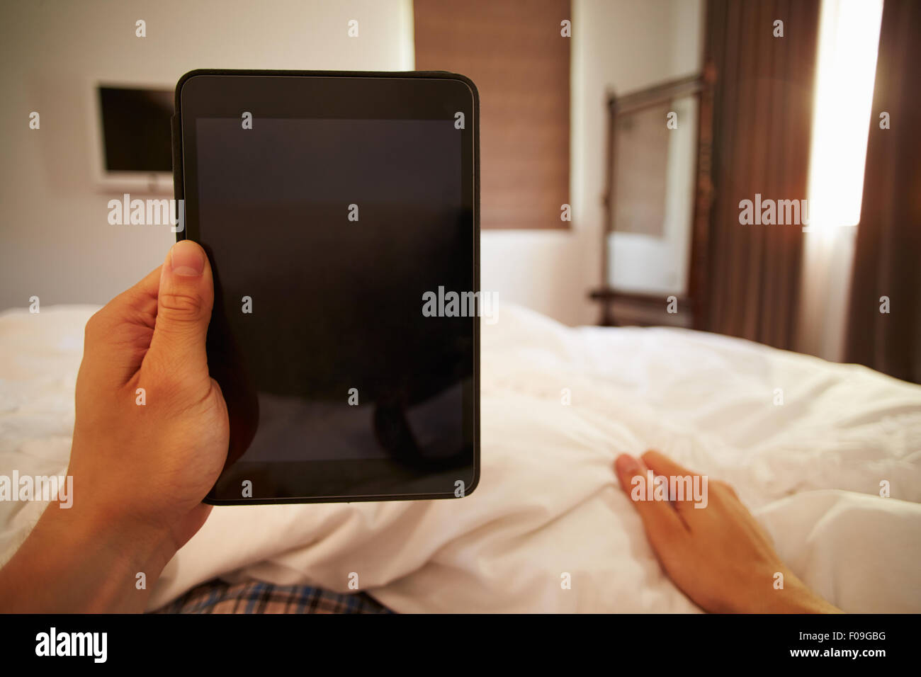 Punto di vista immagine dell uomo nel letto guardando a tavoletta digitale Foto Stock