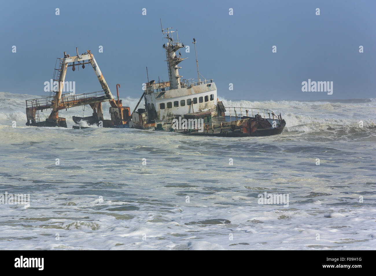 Naufragio di un peschereccio erodendo le onde vicino alla riva. Foto Stock