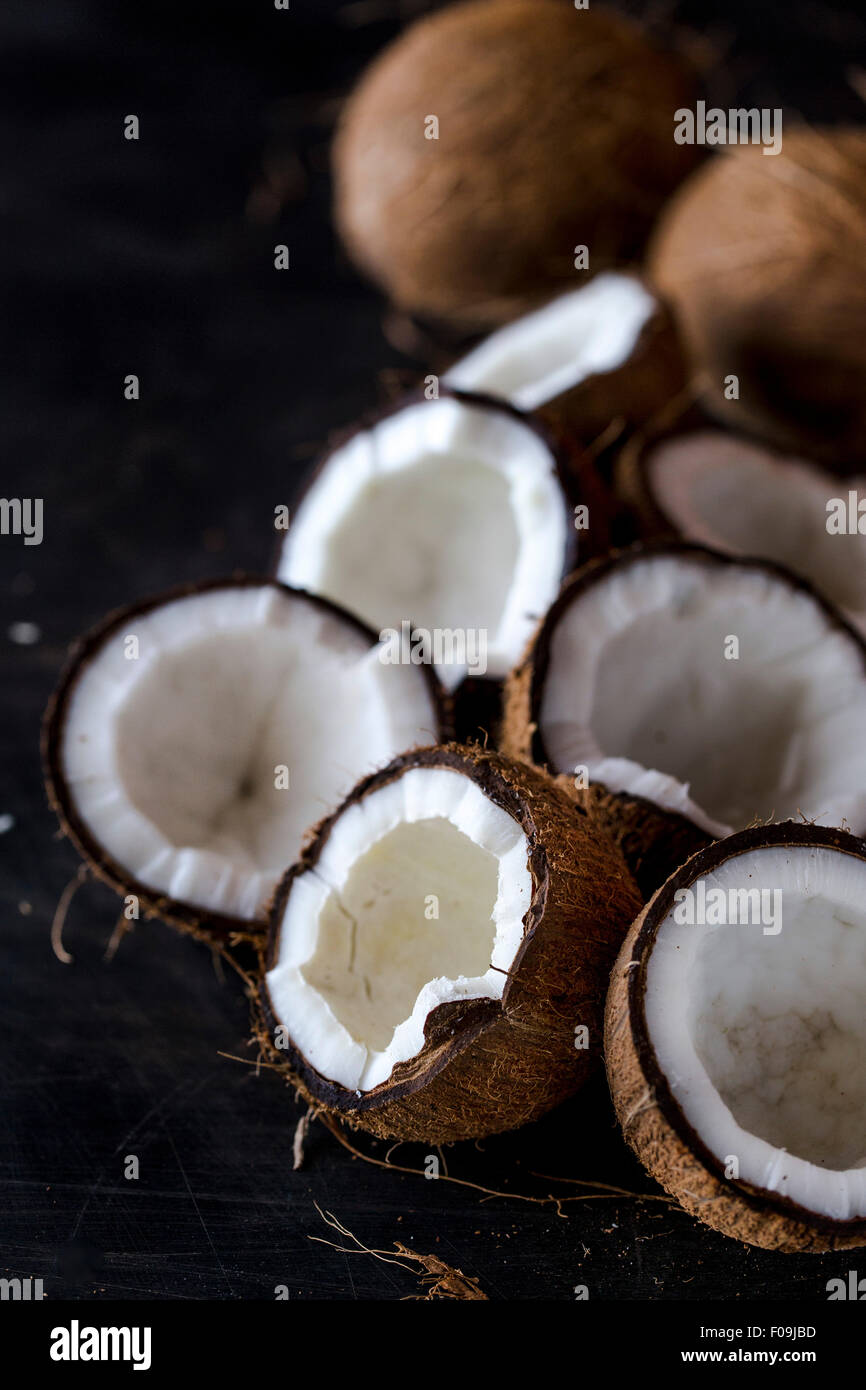 Fresh incrinato noci di cocco vengono visualizzate su uno sfondo scuro Foto Stock
