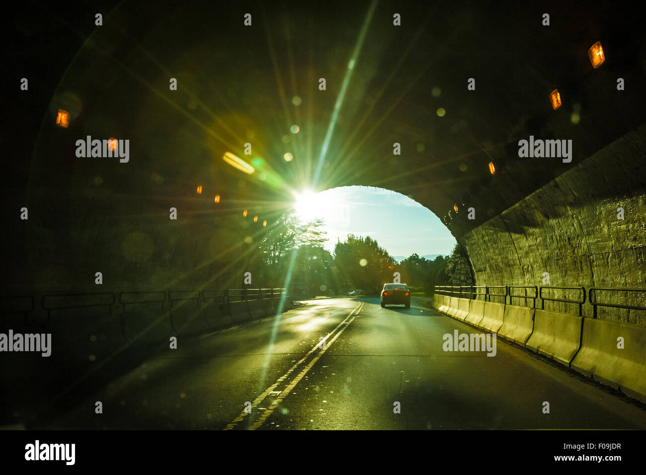Sunburst brillare i raggi in un tunnel oscuro come una vettura esce dal passaggio di montagna in Asheville, North Carolina, Stati Uniti d'America. Foto Stock