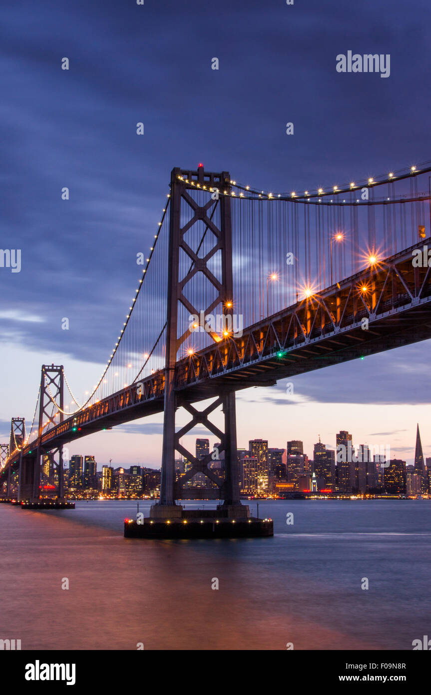 Tramonto su San Francisco-Oakland Bay Bridge e la skyline di San Francisco Foto Stock