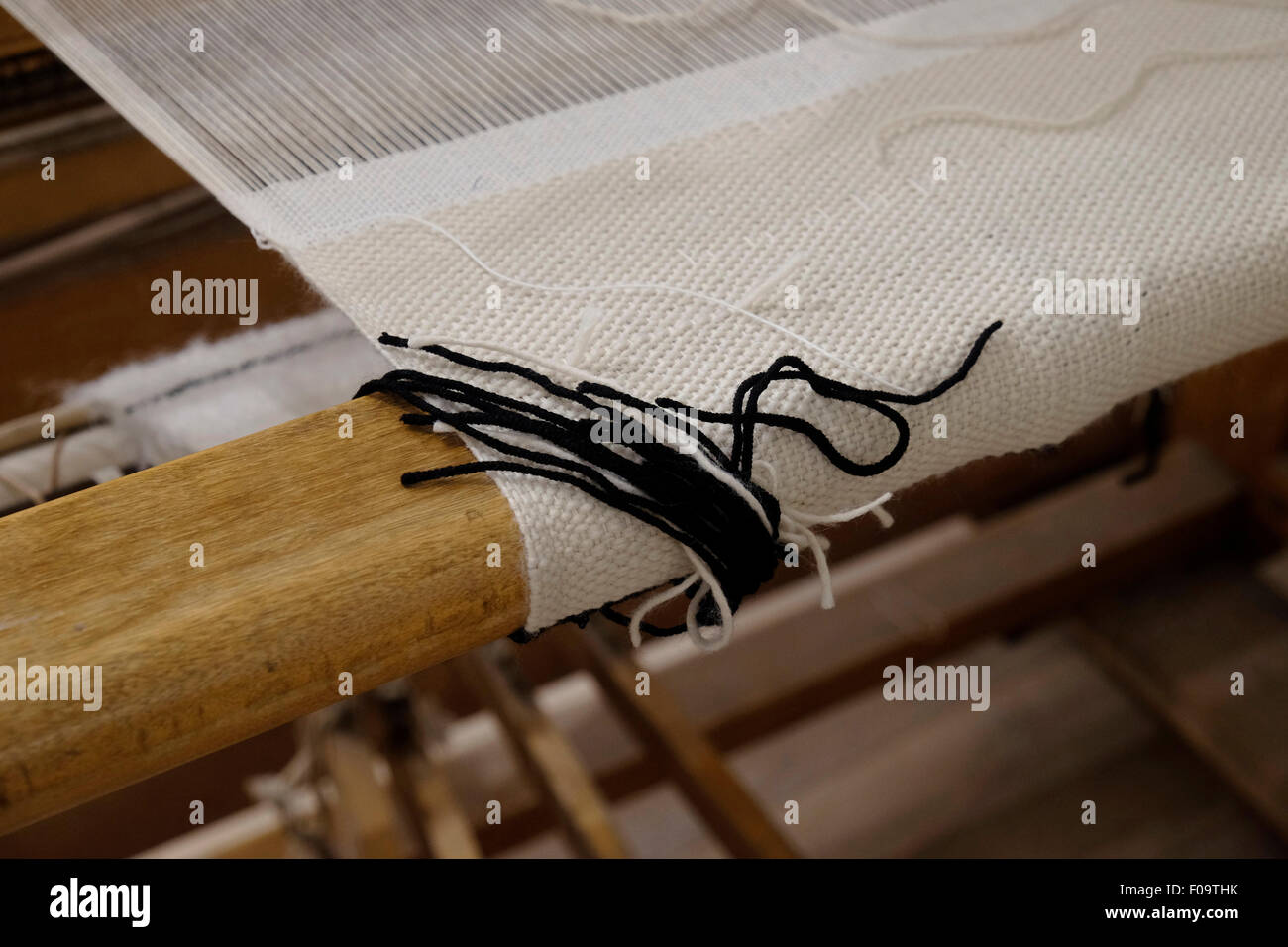 Tradizionale ebraica frange Tzitzis stringhe di un angolo di un Talit preghiera scialle posa in un telaio di tessitura Foto Stock