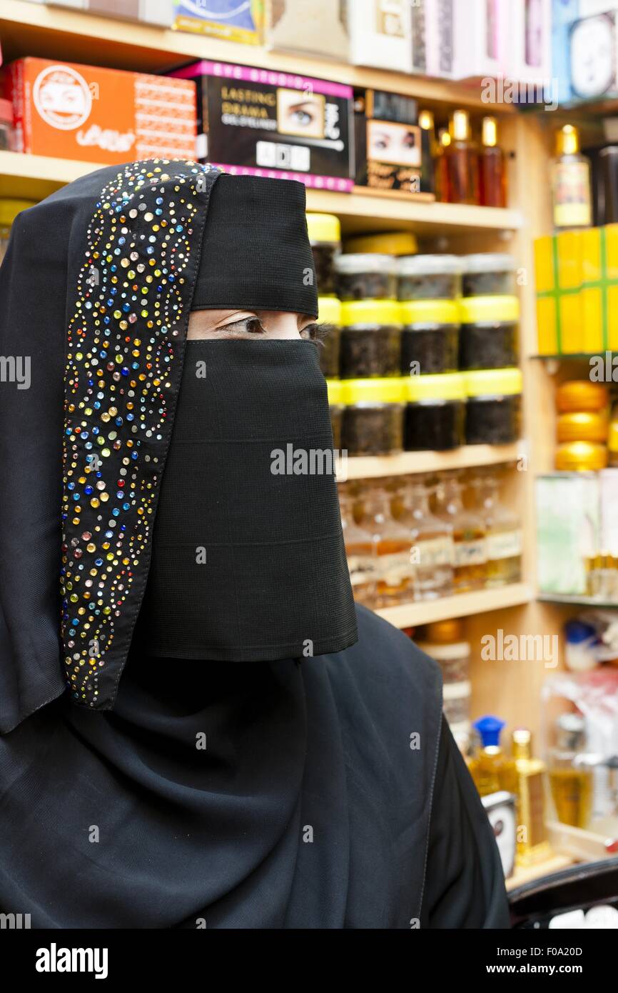 Close-up della donna che indossa burqa la vendita di profumi in Oman Foto Stock