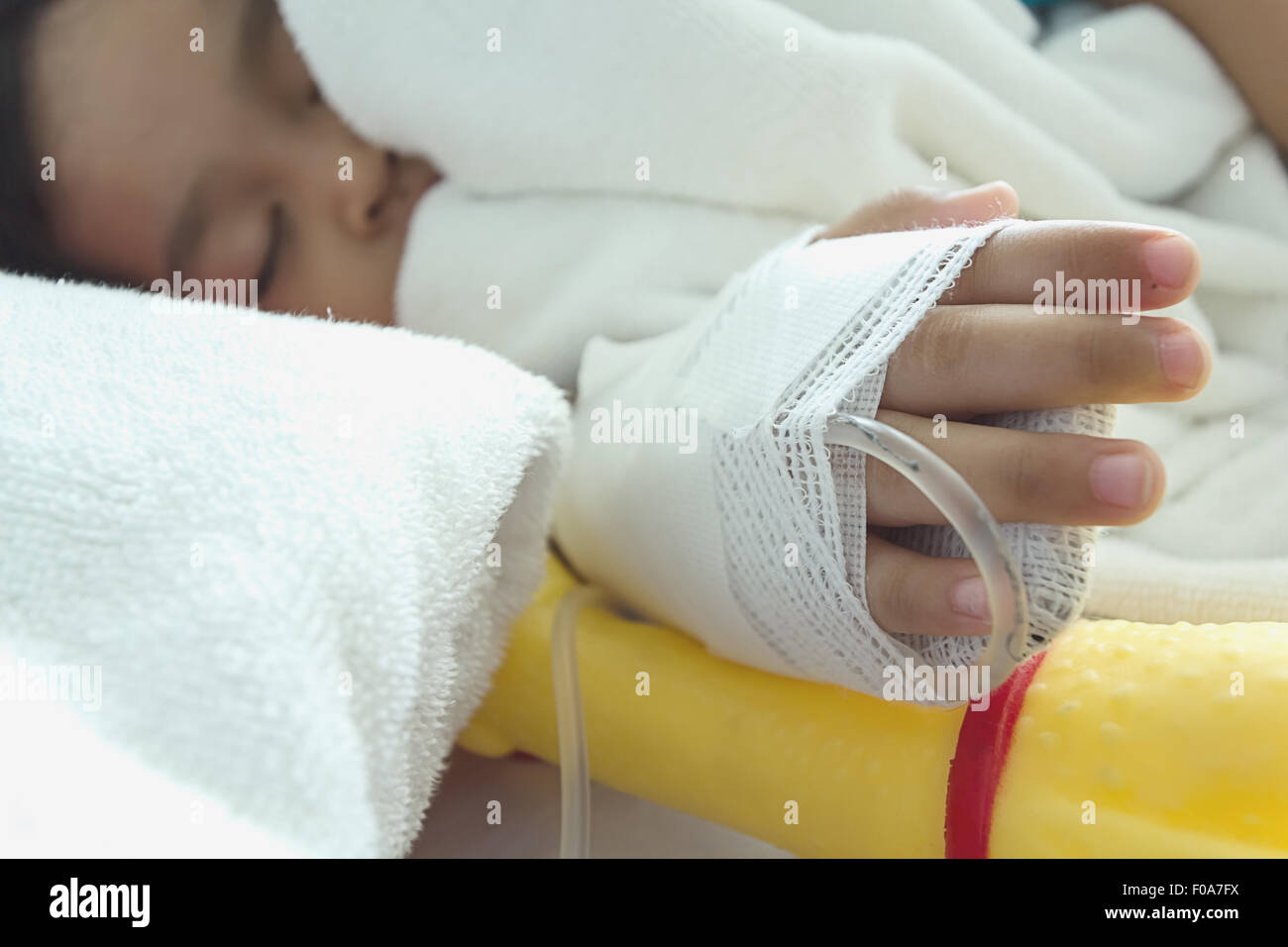 Malattia bambini asiatici addormentato su un sickbed in ospedale, soluzione salina per via intravenosa (IV) a portata di mano Foto Stock