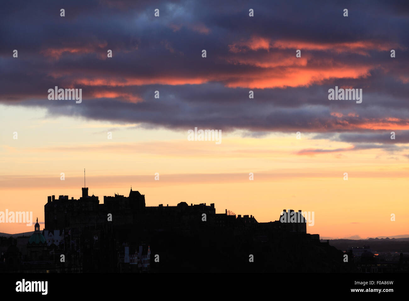 Nuvole scure sul Castello di Edinburgo come il sole tramonta Foto Stock