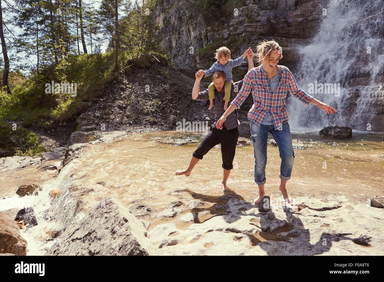 Due generazione famiglia avente divertimento con cascata, Ehrwald, Tirolo, Austria Foto Stock