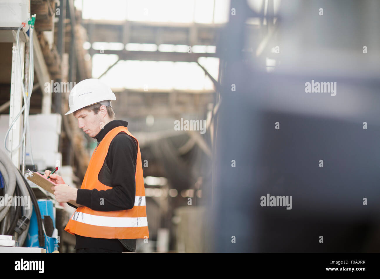 Giovane maschio lavoratore magazzino magazzino tenuto in magazzino Foto Stock