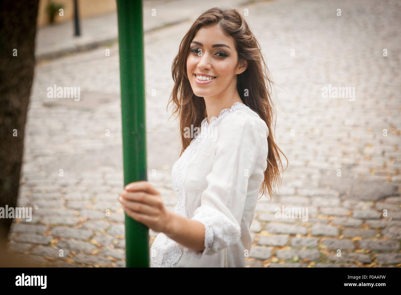 Ritratto di giovane donna, sorridente, tenendo pole Foto Stock