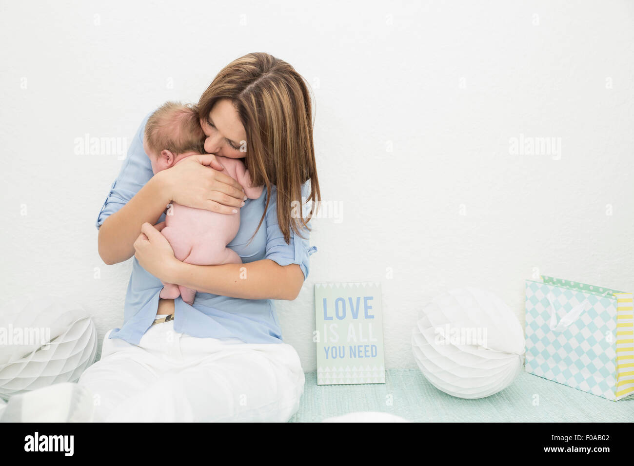 Madre cullano il bambino nelle braccia Foto Stock