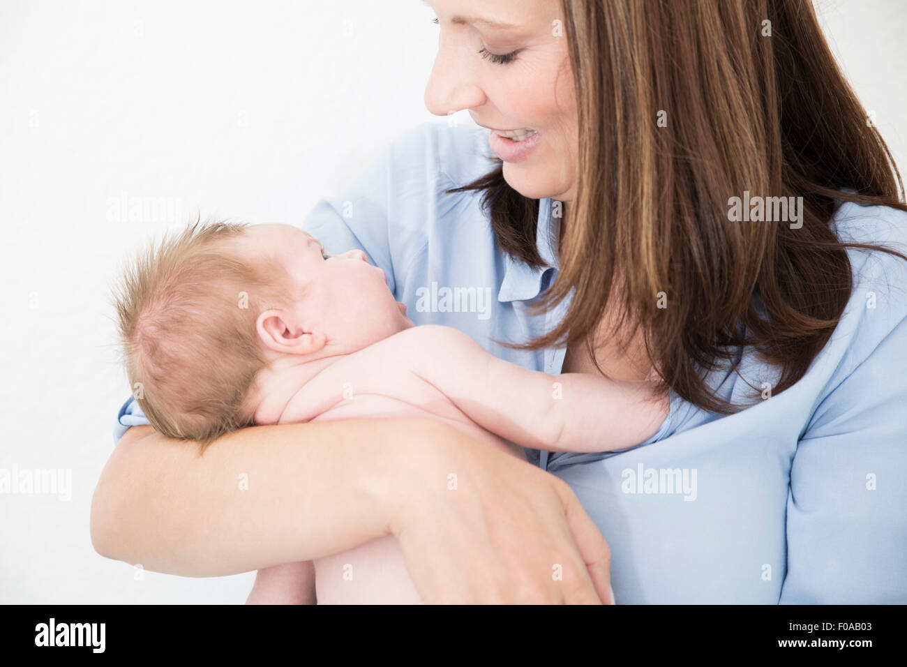 Madre cullano il bambino nelle braccia Foto Stock