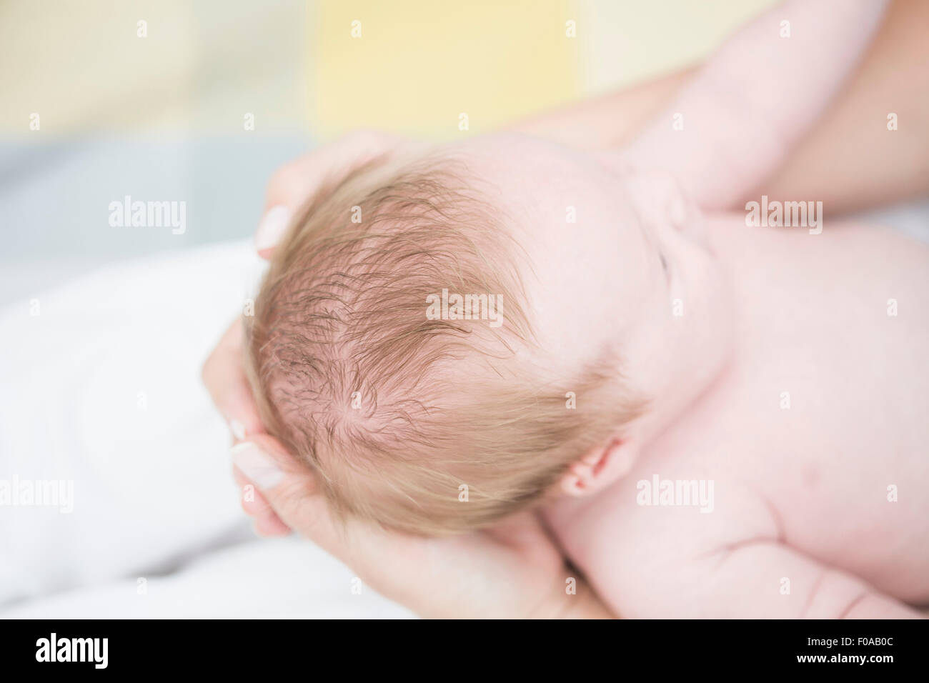 Madre cullano il bambino nelle braccia Foto Stock