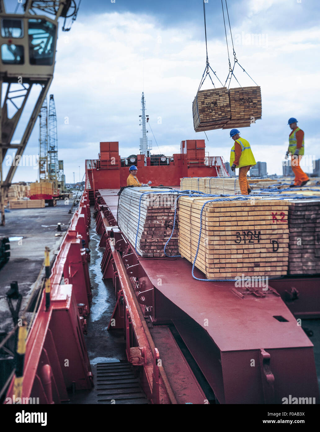Lavoratori legname di scarico dalla nave da carico nel porto di Grimsby, England, Regno Unito Foto Stock