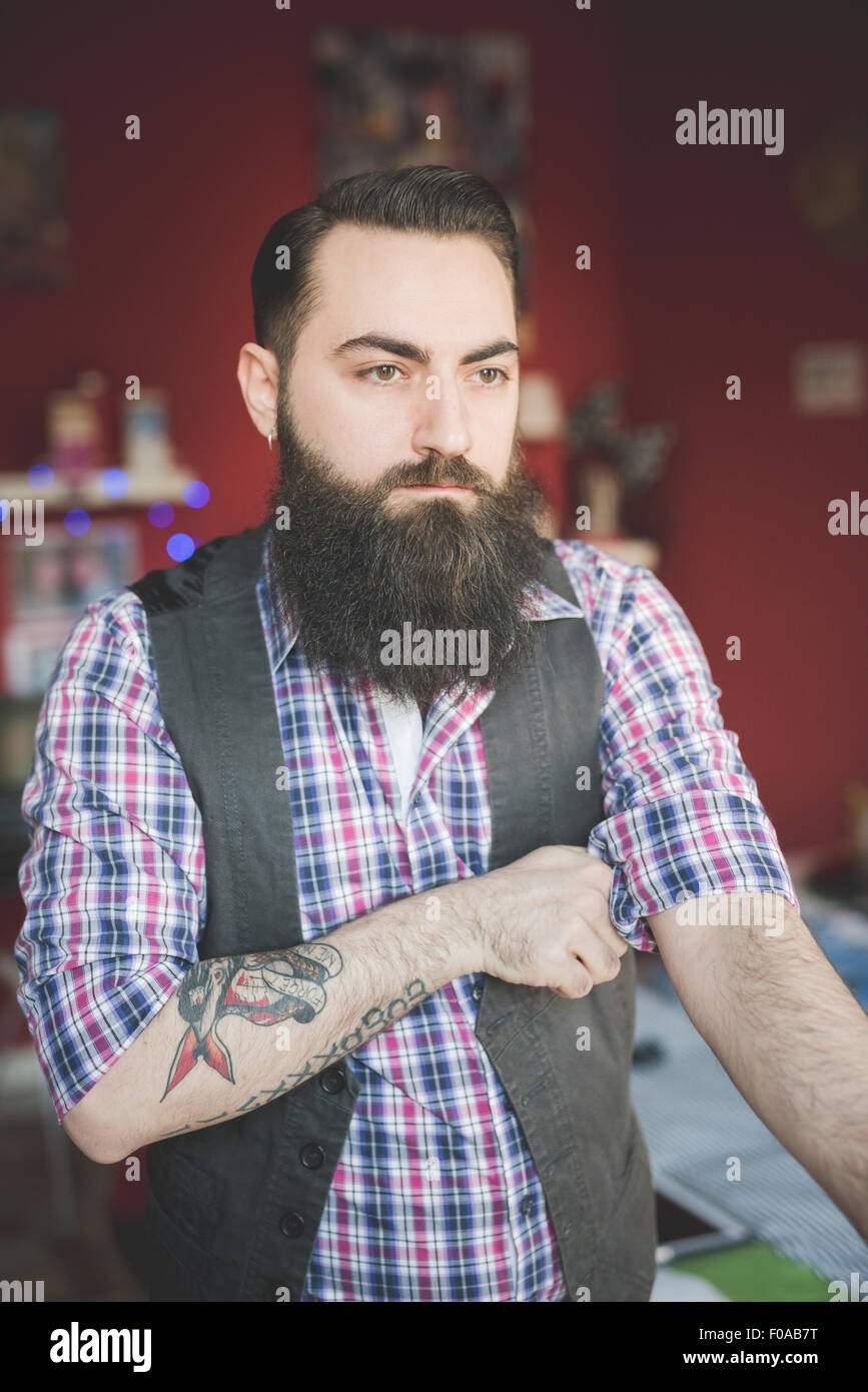 Giovane uomo barbuto la piegatura della manica Foto Stock