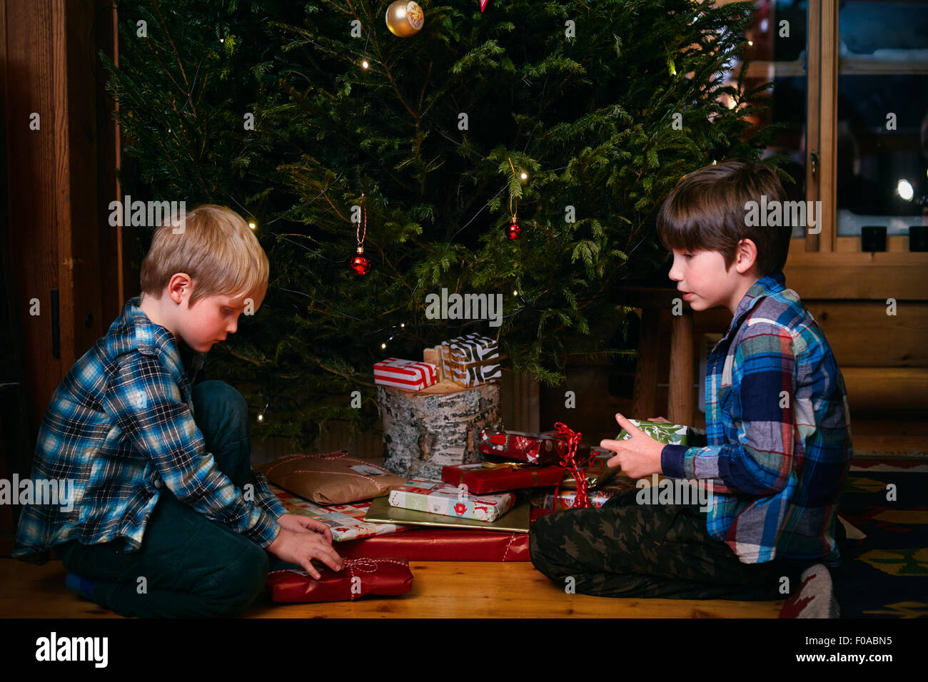 Due fratelli di aprire i regali di Natale Foto Stock