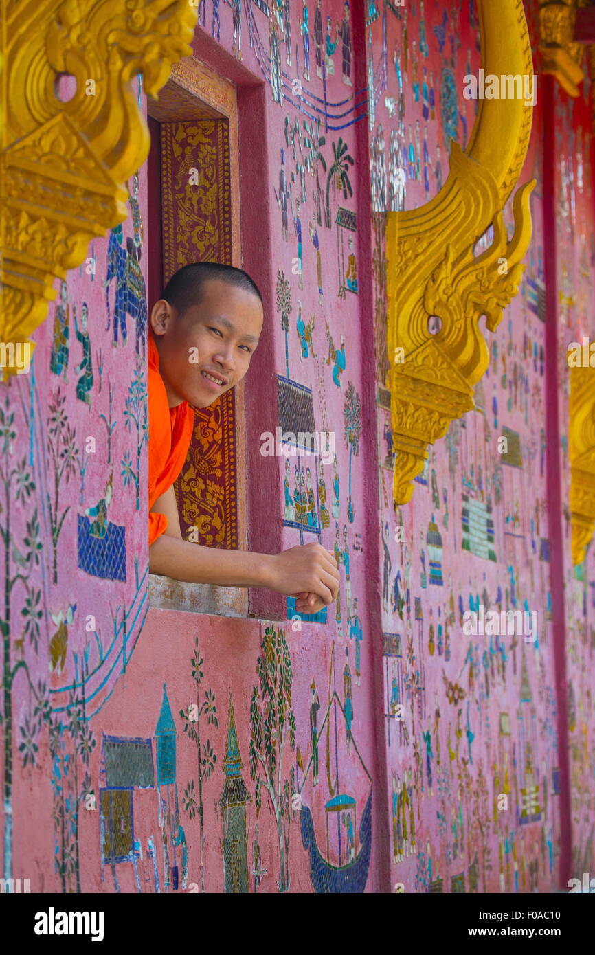 Monaco buddista guardando fuori di Wat Xieng Thong finestra, Luang Prabang, Laos Foto Stock